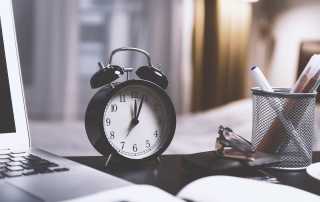 desk with clock and laptop