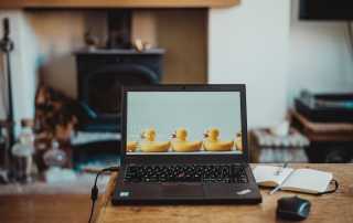 laptop plugged in with rubber duck wallpaper