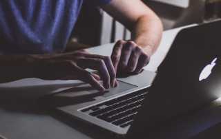 man using Macbook laptop