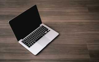 MacBook laptop on brown desk